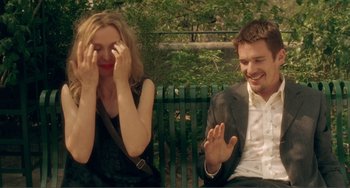 Movie still from “Before Sunset” (2004), directed by Richard Linklater – A man and a woman sitting next to each other on a park bench; Medium shot, Over the shoulder angle