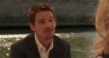 Movie still from “Before Sunset” (2004), directed by Richard Linklater – A person wearing a suit near a body of water; Close Up shot, Over the shoulder angle