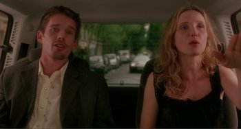 Movie still from “Before Sunset” (2004), directed by Richard Linklater – A man and a woman sitting in the back of a car; Medium shot, Over the shoulder angle