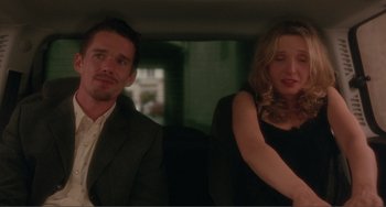 Movie still from “Before Sunset” (2004), directed by Richard Linklater – A man and a woman sitting in the back of a car; Medium shot, Over the shoulder angle