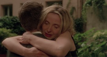 Movie still from “Before Sunset” (2004), directed by Richard Linklater – A woman hugging a young man in a garden setting; Close Up shot, Over the shoulder angle