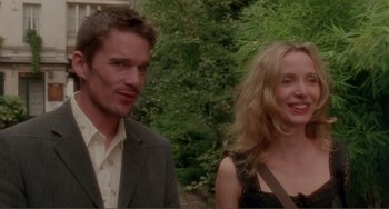 Movie still from “Before Sunset” (2004), directed by Richard Linklater – A man and a woman standing next to each other in front of trees; Close Up shot, Over the shoulder angle