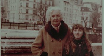 Movie still from “Before Sunset” (2004), directed by Richard Linklater – An older woman and a young girl standing next to each other in front of a building; Medium shot, High angle