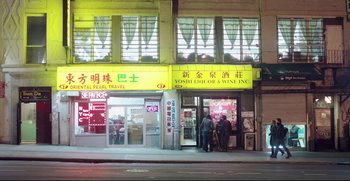 Movie still from “Before We Go” (2014), directed by Chris Evans – Two people standing in front of a liquor and wine store; Extreme Wide shot, Low angle