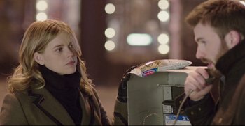 Movie still from “Before We Go” (2014), directed by Chris Evans – A woman sitting in front of a trash can on the street; Close Up shot, Over the shoulder angle