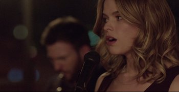 Movie still from “Before We Go” (2014), directed by Chris Evans – A woman holding a microphone in front of a man; Close Up shot, Over the shoulder angle