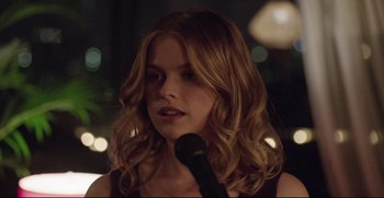 Movie still from “Before We Go” (2014), directed by Chris Evans – A woman with long hair is holding a microphone; Close Up shot, Over the shoulder angle