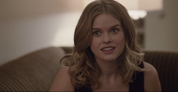 Movie still from “Before We Go” (2014), directed by Chris Evans – A beautiful young lady sitting on top of a couch; Close Up shot, Over the shoulder angle