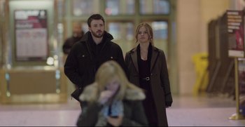 Movie still from “Before We Go” (2014), directed by Chris Evans – A man and a woman standing next to each other in front of a woman; Medium shot, Low angle