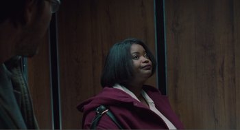 Movie still from “Being John Malkovich” (1999), directed by Spike Jonze – A woman in a purple jacket is looking up; Medium shot, Low angle