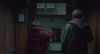 Movie still from “Being John Malkovich” (1999), directed by Spike Jonze – Two people standing in front of a sign; Wide shot, Over the shoulder angle