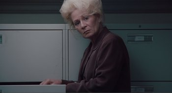 Movie still from “Being John Malkovich” (1999), directed by Spike Jonze – An older woman is standing in front of a filing cabinet; Close Up shot, Low angle