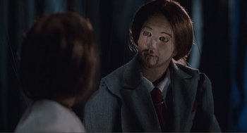 Movie still from “Being John Malkovich” (1999), directed by Spike Jonze – A man in a suit and tie looking into a mirror; Close Up shot, Over the shoulder angle