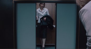 Movie still from “Being John Malkovich” (1999), directed by Spike Jonze – A woman standing in front of a door way; Wide shot, Low angle
