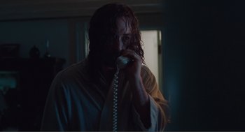 Movie still from “Being John Malkovich” (1999), directed by Spike Jonze – A man with long hair talking on a phone; Medium shot, Low angle