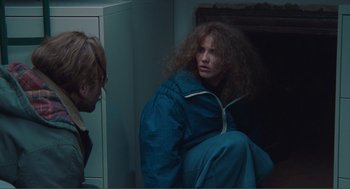 Movie still from “Being John Malkovich” (1999), directed by Spike Jonze – A woman with long hair sitting on the floor; Medium shot, Low angle