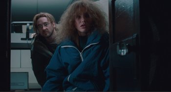 Movie still from “Being John Malkovich” (1999), directed by Spike Jonze – A man and a woman are sitting on a train; Medium shot, Low angle