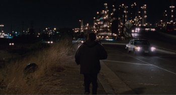 Movie still from “Being John Malkovich” (1999), directed by Spike Jonze – A person walking down a street at night; Extreme Wide shot, Over the shoulder angle