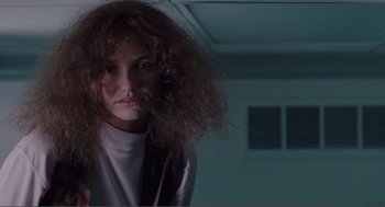 Movie still from “Being John Malkovich” (1999), directed by Spike Jonze – A woman with a messy hair style in a dark room; Close Up shot, Low angle