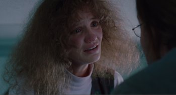Movie still from “Being John Malkovich” (1999), directed by Spike Jonze – A person with long curly hair; Close Up shot, Over the shoulder angle