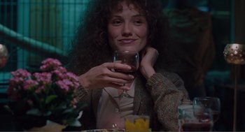 Movie still from “Being John Malkovich” (1999), directed by Spike Jonze – A woman sitting at a table with a glass of wine; Close Up shot, Low angle