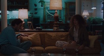 Movie still from “Being John Malkovich” (1999), directed by Spike Jonze – Two people sitting on a couch in a living room; Wide shot, Over the shoulder angle