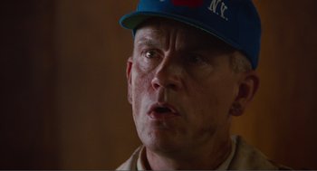 Movie still from “Being John Malkovich” (1999), directed by Spike Jonze – An older man wearing a baseball cap and looking angry; Close Up shot, Low angle