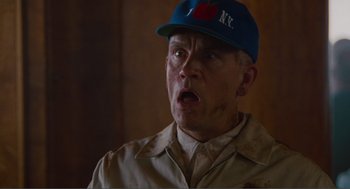 Movie still from “Being John Malkovich” (1999), directed by Spike Jonze – An older man wearing a blue hat and a tan jacket; Close Up shot, Low angle