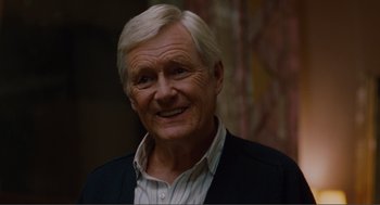 Movie still from “Being John Malkovich” (1999), directed by Spike Jonze – An older man with white hair smiling for the camera; Close Up shot, Over the shoulder angle