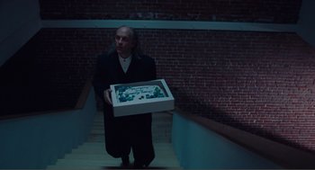 Movie still from “Being John Malkovich” (1999), directed by Spike Jonze – A man holding a box with a birthday cake in it; Medium shot, High angle