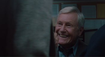 Movie still from “Being John Malkovich” (1999), directed by Spike Jonze – An older man smiling and looking at the camera; Close Up shot, Over the shoulder angle