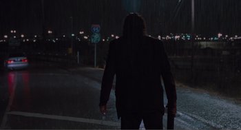 Movie still from “Being John Malkovich” (1999), directed by Spike Jonze – A person walking down a street at night; Wide shot, Low angle