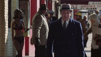 Movie still from “Being There” (1979), directed by Hal Ashby – An older man wearing a hat and a suit walking down the street; Medium shot, Low angle