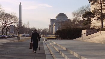 Movie still from “Being There” (1979), directed by Hal Ashby – A woman walking down a sidewalk with a briefcase; Extreme Wide shot, Low angle