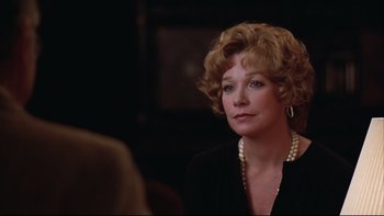 Movie still from “Being There” (1979), directed by Hal Ashby – An older woman wearing a black suit and pearl necklace; Close Up shot, Over the shoulder angle