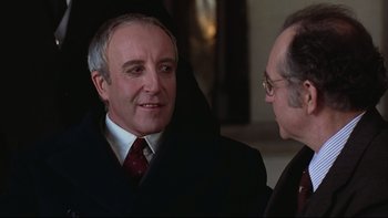 Movie still from “Being There” (1979), directed by Hal Ashby – A man in a suit talking to another man in a suit; Close Up shot, Over the shoulder angle