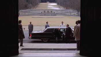 Movie still from “Being There” (1979), directed by Hal Ashby – A group of people standing around a black car; Extreme Wide shot, High angle