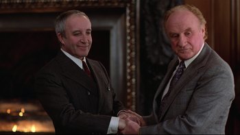 Movie still from “Being There” (1979), directed by Hal Ashby – Two men in suits shaking hands in front of a mirror; Medium shot, Low angle