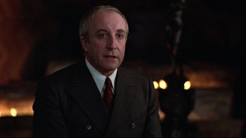 Movie still from “Being There” (1979), directed by Hal Ashby – A man in a suit and tie in a dark room; Close Up shot, Low angle
