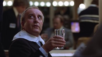 Movie still from “Being There” (1979), directed by Hal Ashby – A man holding a glass of water in his hand; Close Up shot, Low angle