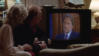 Movie still from “Being There” (1979), directed by Hal Ashby – A man and a woman sitting in front of a television; Close Up shot, Over the shoulder angle