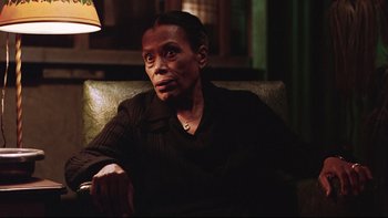 Movie still from “Being There” (1979), directed by Hal Ashby – An older woman sitting on a couch in a dark room; Close Up shot, Over the shoulder angle