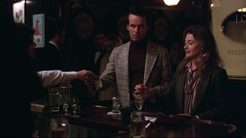 Movie still from “Being There” (1979), directed by Hal Ashby – A man and a woman at a bar shaking hands; Medium shot, Over the shoulder angle