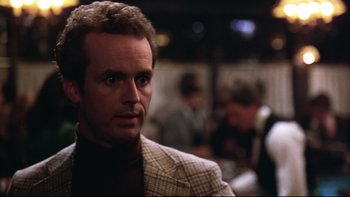 Movie still from “Being There” (1979), directed by Hal Ashby – A person wearing a suit and tie; Close Up shot, Over the shoulder angle