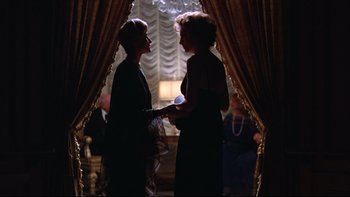 Movie still from “Being There” (1979), directed by Hal Ashby – Two women are standing in front of a window; Medium shot, Over the shoulder angle