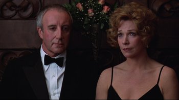 Movie still from “Being There” (1979), directed by Hal Ashby – A man and a woman standing next to each other in front of flowers; Close Up shot, Low angle