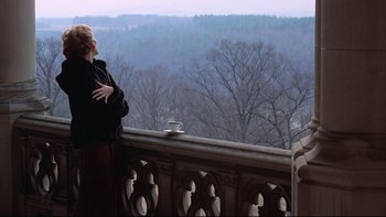 Movie still from “Being There” (1979), directed by Hal Ashby – A woman standing on a balcony with a cup of coffee; Wide shot, Over the shoulder angle