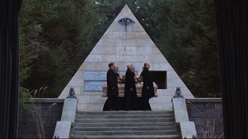 Movie still from “Being There” (1979), directed by Hal Ashby – Three men in black robes carrying a coffin; Extreme Wide shot, Low angle