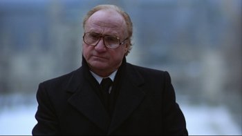 Movie still from “Being There” (1979), directed by Hal Ashby – An older man wearing a suit and glasses; Close Up shot, Low angle
