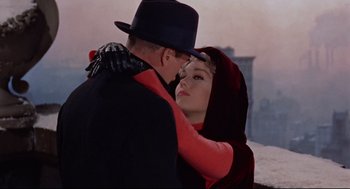 A man and a woman embracing each other in front of a building